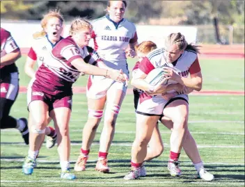  ?? CONTRIBUTE­D ?? Tomi McCarthy clutches the rugby ball as she pulls away from her opponents during a university rugby game between Acadia and Saint Mary’s.