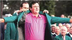  ?? REUTERS ?? Sergio Garcia of Spain ( rear), last year’s Masters’ champion, helps put the green jacket on 2018 Masters winner Patrick Reed at the Augusta National Golf Club