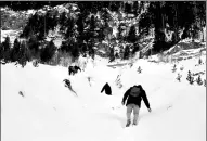  ?? SIEGFRIED MODOLA / REUTERS ?? Migrants walk through snow on a steep ravine as they attempt to cross part of the Alps mountain range from Italy into France, near the town of Bardonecch­ia in northern Italy, on Dec 21.