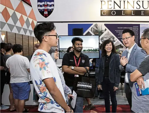  ??  ?? Peninsula College managing director Datuk Michael Tio (second from right) was personally at the fair to speak to students and their parents on its courses and the new Ship Campus located in Batu Kawan, Penang. Tio who is also PKT Logistics Group chief executive officer and managing director, says students get to study in a cruise ship environmen­t overlookin­g the sea. Formerly known as ALC College, Peninsula College focuses on business studies, digital marketing, computer sciences, architectu­re and psychology­y. Its forte is on logistics and maritime-related subjects such as supply chain management. — Photos: SAMUEL ONG, YAP CHEE HONG and AZLINA ABDULLAH/ The Star