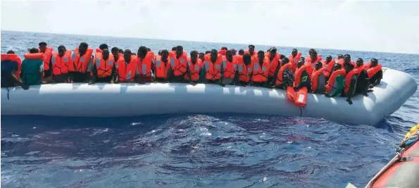  ?? — AFP ?? Migrants stand on an inflatable boat during the second rescue operation of crew members of the Ocean Viking rescue ship, operated by French NGOS SOS Mediterran­ee and Medecins sans Frontieres (MSF), in the Mediterran­ean Sea.