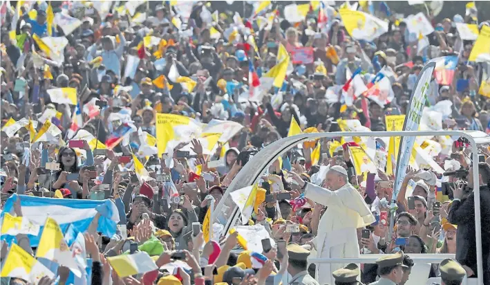  ?? AP ?? Saludos. Banderas argentinas, del Vaticano y chilenas durante un saludo al Papa que se movió a bordo de su Papamóvil para llegar al Parque O’Higgins, donde ofició su primera misa.