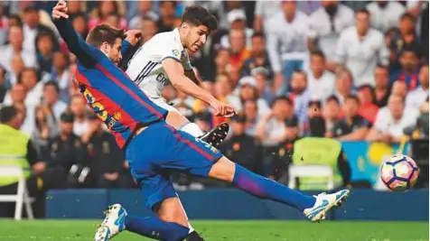  ?? Rex Features ?? Gerard Pique of Barcelona and Marco Asensio of Real Madrid in action during a La Liga match-up last season. European champions Real will meet arch-rivals Barcelona in Miami on July 29 — the first Clasico held outside Spain since 1982.