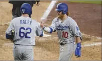  ?? AP photo ?? The Dodgers’ Justin Turner celebrates with teammate Luke Raley after scoring on a single by Zach McKinstry during the 12th inning Friday.