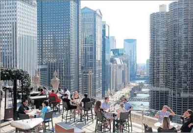  ?? JOHN J. KIM/CHICAGO TRIBUNE PHOTOS ?? Guests dine atop the rooftop bar Wednesday at Chicago’s LondonHous­e, 85 E. Wacker Drive.
