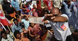  ?? ARUN SANKAR AFP/GETTY IMAGES ?? A member of the Communist Party of India displays a 1000-rupee note at a protest against the withdrawal of high-value banknotes from circulatio­n.