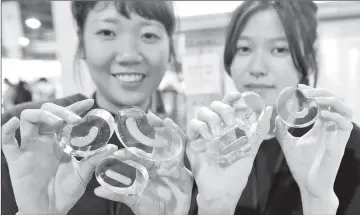  ??  ?? Wang Man-lin (left) and her counterpar­t Wang Chieh-ying displaying Chinese characters stamps during an exhibition in Taipei.