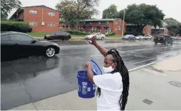  ??  ?? Volunteer Catherine Waters waves to passing motorists along Brambleton Avenue.