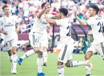  ??  ?? ALEGRÍA. Marco Asensio es felicitado por Lucas Vásquez y Dani Ceballos en uno de los dos goles que anotó a la Juventus.