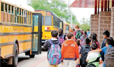  ?? [PHOTO BY SARAH PHIPPS, THE OKLAHOMAN] ?? Students board buses Tuesday at Cesar Chavez Elementary school in Oklahoma City. School districts across the state are working to formulate a budget for next year without knowing what funding will be.