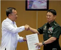  ?? AP ?? Philippine Drug Enforcemen­t Agency Director General Isidro Lapena shakes hands with Philippine military chief Gen. Eduardo Ano after signing rites at Camp Aguinaldo military headquarte­rs in Quezon city, north of Manila, Philippine­s, on Tuesday. —