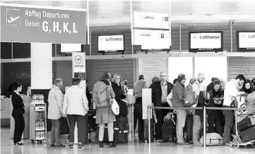 ??  ?? Passengers queue at a Lufthansa counter at the Franz-Josef-Strauss-airport in Munich, southern Germany. — AFP photo