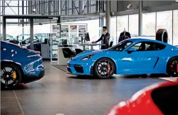  ?? LIESA JOHANNSSEN-KOPPITZ / GETTY IMAGES ?? A range of Porsche automobile­s are displayed at a showroom in Berlin, Germany, on March 29, 2022.