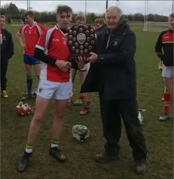  ??  ?? Paddy Barron receiving the shield from Pat Henderson, South Leinster Schools Servicing Officer.