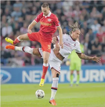  ?? ERMINDO ARMINO/THE ASSOCIATED PRESS ?? AC Milan’s Philippe Mexes, right, fights for the ball with Tim Matavz from PSV Eindhoven during their Champions League match in Eindhoven, the Netherland­s on Tuesday. The game ended in a 1-1 draw.