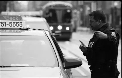  ?? CP PHOTO ?? A police constable speaks to a taxis driver during the second day of the King Street Transit Pilot involving city streetcars on Monday.