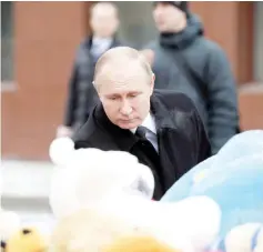  ?? — AFP photo ?? Putin lays flowers in tribute to the fire victims.