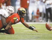  ??  ?? Maryland quarterbac­k Kasim Hill, right, fumbles as he is stopped by Temple defensive tackle Michael Dogbe in the first half of the Owls’ 35-14 victory in College Park, Md. The Terps recovered the ball.