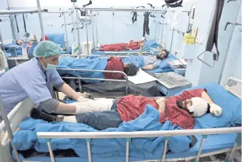  ??  ?? Hombres heridos reciben atención en un hospital de Kabul, Afganistán, después de un atentado suicida perpetrado durante una reunión de académicos religiosos con motivo del aniversari­o del nacimiento del profeta Mahoma.
