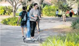  ?? ORLANDO SENTINEL FILE ?? As many as three UCF students at a time are riding the electric rental scooters on campus. Because the scooters literally turn off at the edge of campus, the little vehicles pile up at times there.