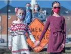  ?? ROBERT SCHEER/INDIANAPOL­IS STAR ?? Brienne Babione, 9, left, and sister Blair, 11, visited Carmel, Ind., City Hall hoping to persuade the city to abandon gendered signage in constructi­on zones. At rear are their parents, John and Leslie Babione.