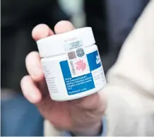  ?? MARTIN OUELLET-DIOTTE/AFP/GETTY IMAGES ?? A customer shows a recreation­al pot product purchased from a cannabis store Wednesday in Montreal. The items must follow strict packaging and labelling regulation­s.