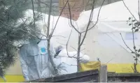  ??  ?? ●●Forensic officers in the back garden of the property in Matlock Road, Reddish