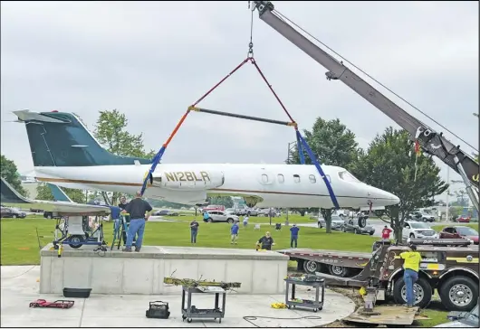  ?? ?? Using a crane, crews from Sandy's Towing company finished the placement of the Learjet 28, the newest
exhibit at the Armstrong Air and Space Museum. A dedication ceremony is set for July 20.