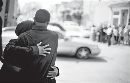  ?? David Goldman
Associated Press ?? A COUPLE
embrace as people gather near the Charleston, S.C., NAACP office for a news conference on the death of Walter L. Scott.