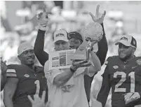  ?? CHUCK BURTON/AP ?? Virginia coach Bronco Mendenhall holds up the Belk Bowl trophy after the Cavaliers defeated South Carolina in Charlotte, N.C., on Saturday.PLAYOFF COVERAGE ONLINE