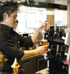  ?? — Japan News-Yomiuri photo ?? Craft beer is poured from Kirin Brewery Co.’s Tap Marche server in Chuo Ward, Tokyo.