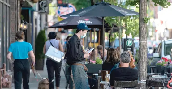  ?? TYLER LARIVIERE/SUN-TIMES ?? FRAN SPIELMAN, CITY HALL REPORTER
A server at Cere’s Table takes a couple’s order as they dine outside Thursday. Illinois is set to enter Phase 4 of the state’s reopening plan on Friday.