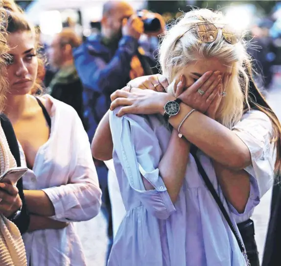  ?? FOTO: REUTERS ?? Una mujer llora tras dejar una vela en honor a las víctimas del atentado del lunes pasado, en el centro de Manchester.