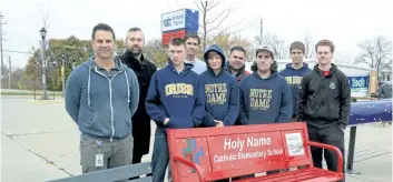  ?? MICHELLE ALLENBERG/ WELLAND TRIBUNE ?? A group of Niagara Catholic District School Board students and teachers stand behind one of 10 benches students built for Welland Transit Terminal. .