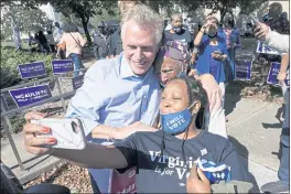  ?? STEVE HELBER — THE ASSOCIATED PRESS FILE ?? Democratic gubernator­ial candidate Terry McAuliffe, left, poses for a photo with supporters after a rally in Norfolk, Va.