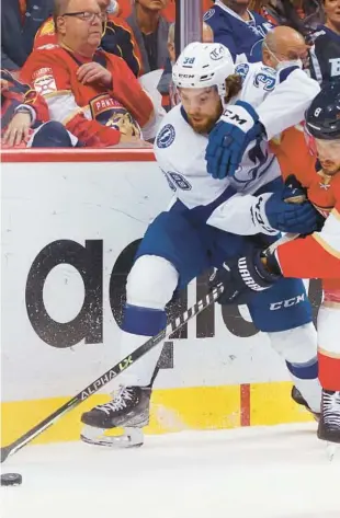  ?? REINHOLD MATAY/AP ?? Panthers defenseman Ben Chiarot, right, and Lightning left wing Brandon Hagel vie for the puck during the first period of Game 2 Thursday night.