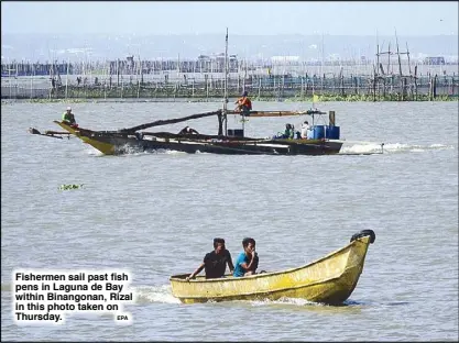  ?? EPA ?? Fishermen sail past fish pens in Laguna de Bay within Binangonan, Rizal in this photo taken on Thursday.
