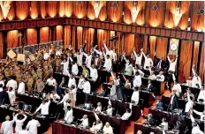  ??  ?? Police officials gather to escort Speaker Karu Jayasuriya following a commotion in parliament (AFP)