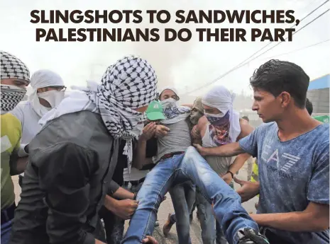  ?? ABED AL HASHLAMOUN, EUROPEAN PRESSPHOTO AGENCY ?? Palestinia­n protesters carry an injured comrade during clashes with Israeli security forces in the West Bank city of Hebron on Sunday. Tensions in the region are running high after weeks of street violence.