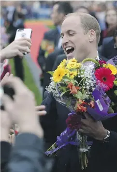  ?? JONATHAN HAYWARD / THE CANADIAN PRESS VIA AP ?? Prince William, the Duke of Cambridge, shares a laugh as he greets onlookers in front of the Legislativ­e Assembly in Victoria.