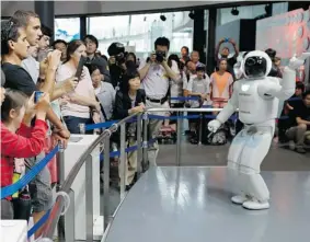  ?? SHIZUO KAMBAYASHI/THE Associated Press ?? Honda Motor Co.ís interactiv­e robot Asimo gestures while talking with visitors
at a demonstrat­ion event at the Miraikan science museum, in Tokyo.