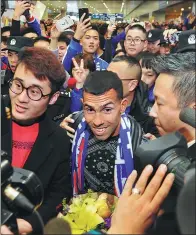  ?? XINHUA ?? Top: Carlos Tevez is put through his paces with his Boca Juniors teammates in Buenos Aires on Friday. The former Manchester United and Juventus striker agreed to return for a third stint at his boyhood club after a forgettabl­e 12 months in China with Shanghai Shenhua. AFP Left: Tevez cuts a dejected figure on the pitch during his miserable spell with Shenhua last season — a stark contrast to the hysteria that greeted his arrival in Shanghai last January (right).