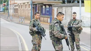  ?? AP PHOTO ?? French soldiers stand guard outside the scene of an attack in Saint Etienne du Rouvray, Normandy, France, Tuesday. Two attackers invaded a church Tuesday during morning Mass, killing an 84-year-old priest by slitting his throat and taking hostages...