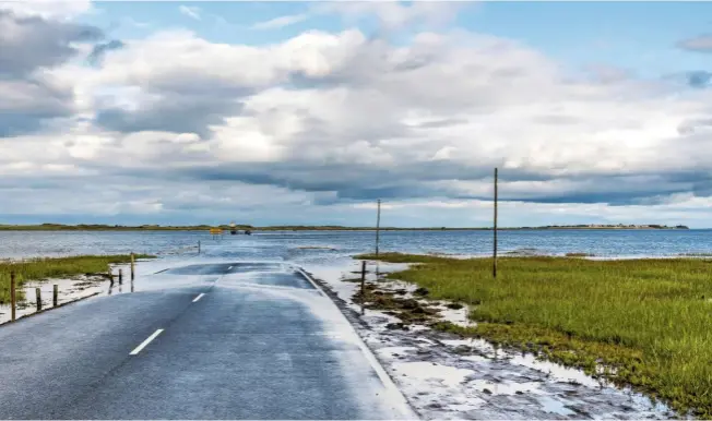  ??  ?? The road linking Beal and Lindisfarn­e in Northumber­land lies submerged until the tide goes out, twice a day, enabling cars to pass between the holy island and the mainland.