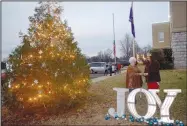  ?? Westside Eagle Observer/MIKE ECKELS ?? Pat Austin (left) and the reigning Miss Decatur Barbecue, Emma Haag, turn on the Decatur Christmas tree at City Hall in Decatur Friday night. The lighting of the city tree marked the beginning of the Decatur Chamber of Commerce’s annual Christmas parade through downtown Decatur.