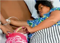  ?? AFP ?? Dinar tends to her newborn baby in Pantoloan, Indonesia. —