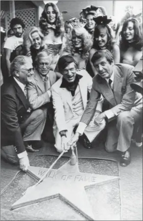  ?? FILE — THE ASSOCIATED PRESS ?? In this file photo, Chairman of the Board, Playboy Enterprise­s Inc., Hugh Hefner, center, receives a star on the Hollywood Walk of Fame in Los Angeles. Honorary Mayor of Hollywood, Monty Hall, right, holds the rope attached to the new star with Hefner....