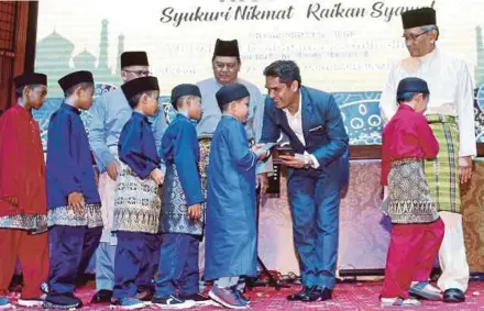  ?? [FOTO MOHAMAD SHAHRIL BADRI SAALI/BH] ?? Mohd Radzi menyampaik­an duit raya kepada anak yatim pada Majlis Sambutan Hari Raya Aidilfitri RISDA 2019 di Kuala Lumpur, semalam.