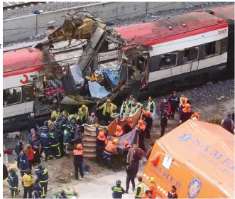  ??  ?? FILE - In this March 11, 2004 file photo, rescue workers cover bodies alongside a bomb-damaged passenger train, following a number of explosions in Madrid, Spain, which killed more than 170 rushhour commuters and wounded more than 500 in Spain's worst terrorist attack ever. An Al-Qaida-linked group that claimed responsibi­lity for the Madrid train bombings warned European nations that they have only two weeks to withdraw troops from Iraq or face the consequenc­es, a panArab newspaper reported Friday, July 2, 2004.