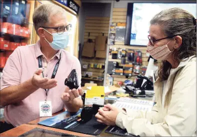  ?? Ned Gerard / Hearst Connecticu­t Media ?? Sales associate Jeff Scholl assists Dawn Tischbein, of Killingwor­th, as she shops for a digital camera at Milford Photo in Milford on Wednesday.